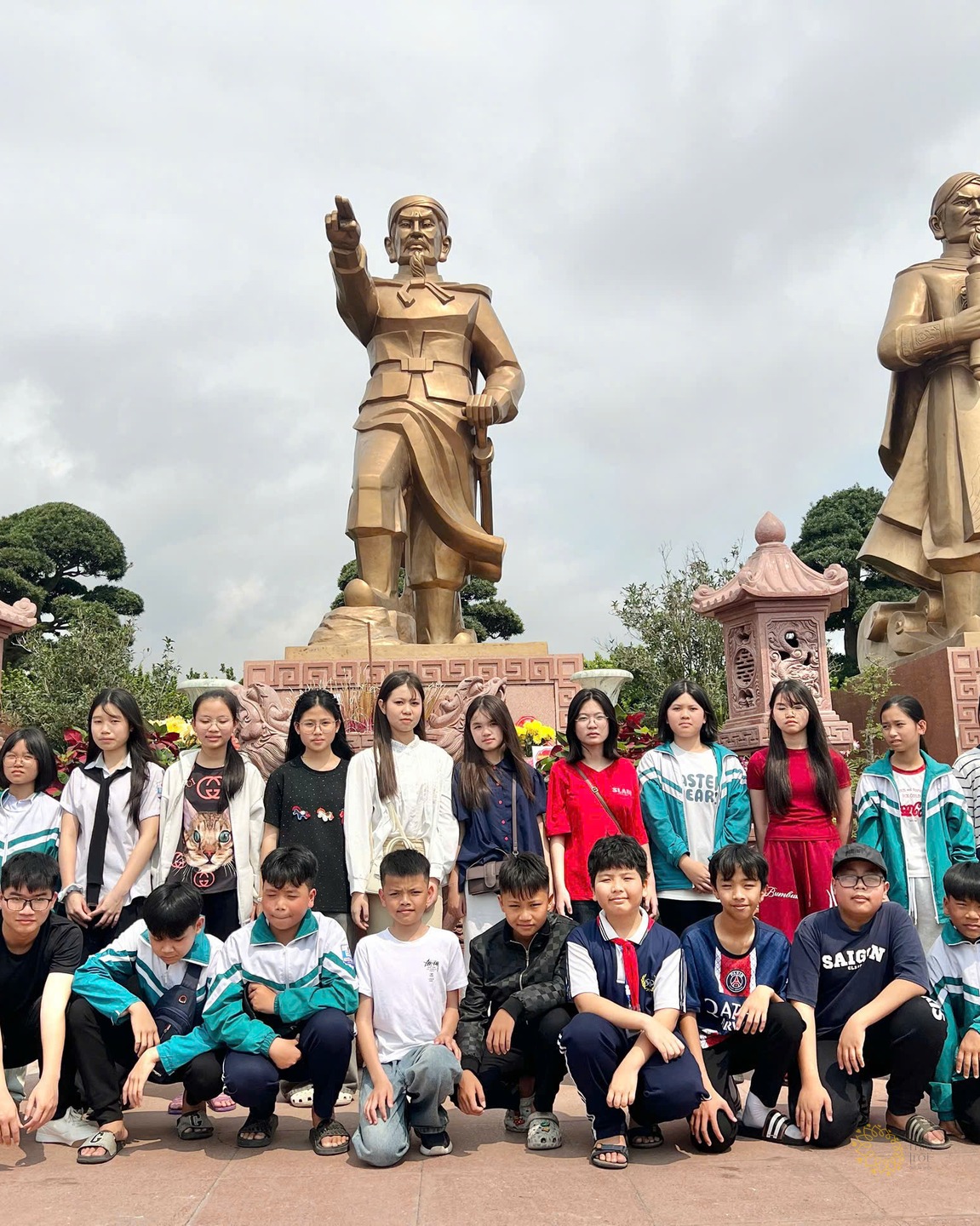 Học sinh Trường Tân Khánh chụp ảnh tập thể dưới chân tượng đài ba vị anh hùng dân tộc tại Khu di tích Bạch Đằng Giang.