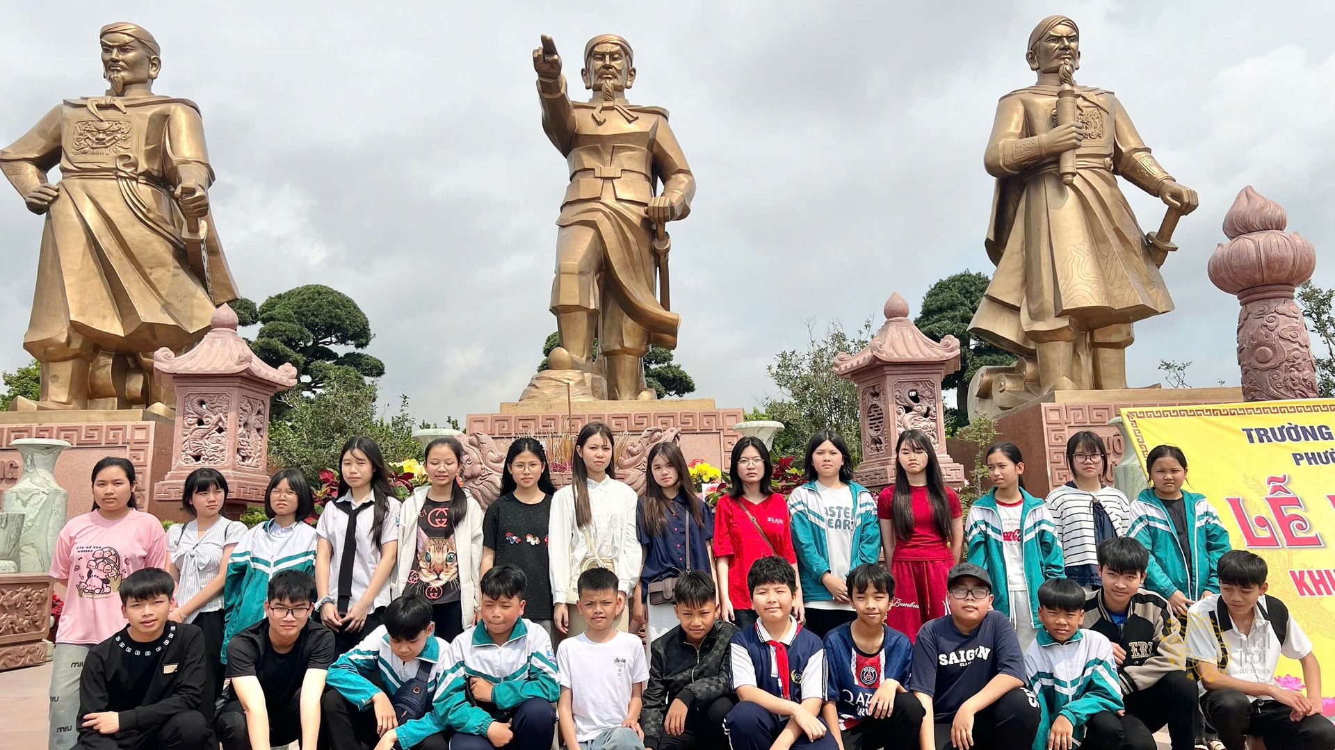 Học sinh Trường Tân Khánh chụp ảnh tập thể dưới chân tượng đài ba vị anh hùng dân tộc tại Khu di tích Bạch Đằng Giang.